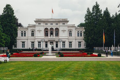 Außenansicht der Villa Hammerschmidt mit Springbrunnen und Blumenbeeten im Park