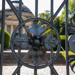 Blick durch das schmiedeeiserne Gitter auf das Mausoleum von Carstanjen