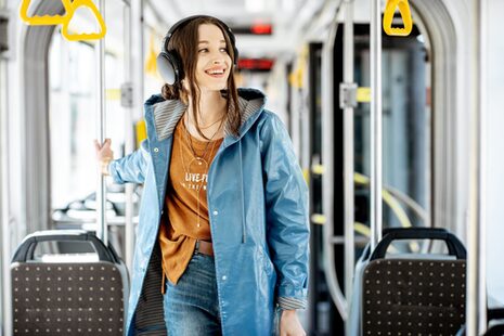 Eine Frau steht in einer Straßenbahn.