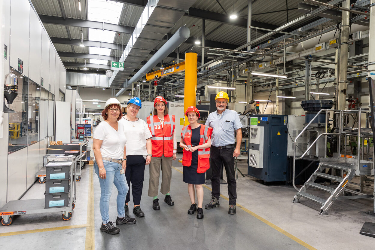 Das Bild zeigt OB Katja Dörner und Wirtschaftsförderin Viktoria Appelbe (in orangefarbenen Westen) bei der Besichtigung des Werksgeländes von SGL Carbon.