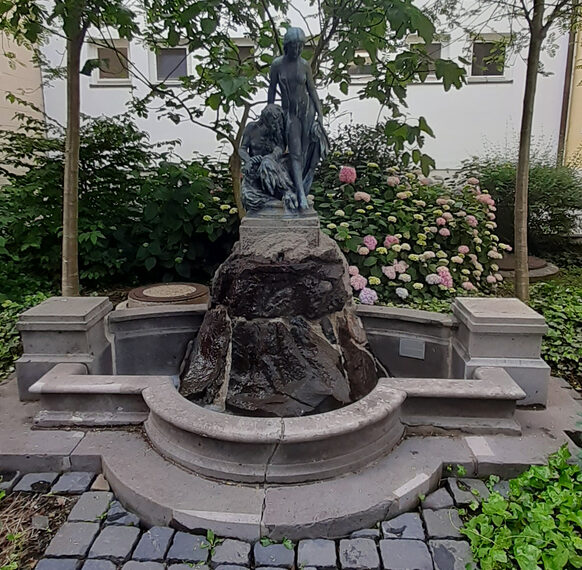 Das Foto zeigt den Springbrunnen mit der Skulptur "Faun und Nymphe" am Haus an der Redoute in Bad Godesberg.