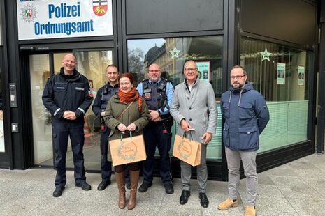 Sechs Personen stehen vor dem Eingang eines Gebäudes, das eine große Tafel über der Tür als "Gemeinsame Anlaufstelle Bonn Innenstadt" von Polizei und Ordnungsamt ausweist.