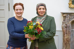 Gruppenbild: Oberbürgermeisterin Katja Dörner dankt Ümmü Gülsüm Karakus mit einem Blumenstrauß.