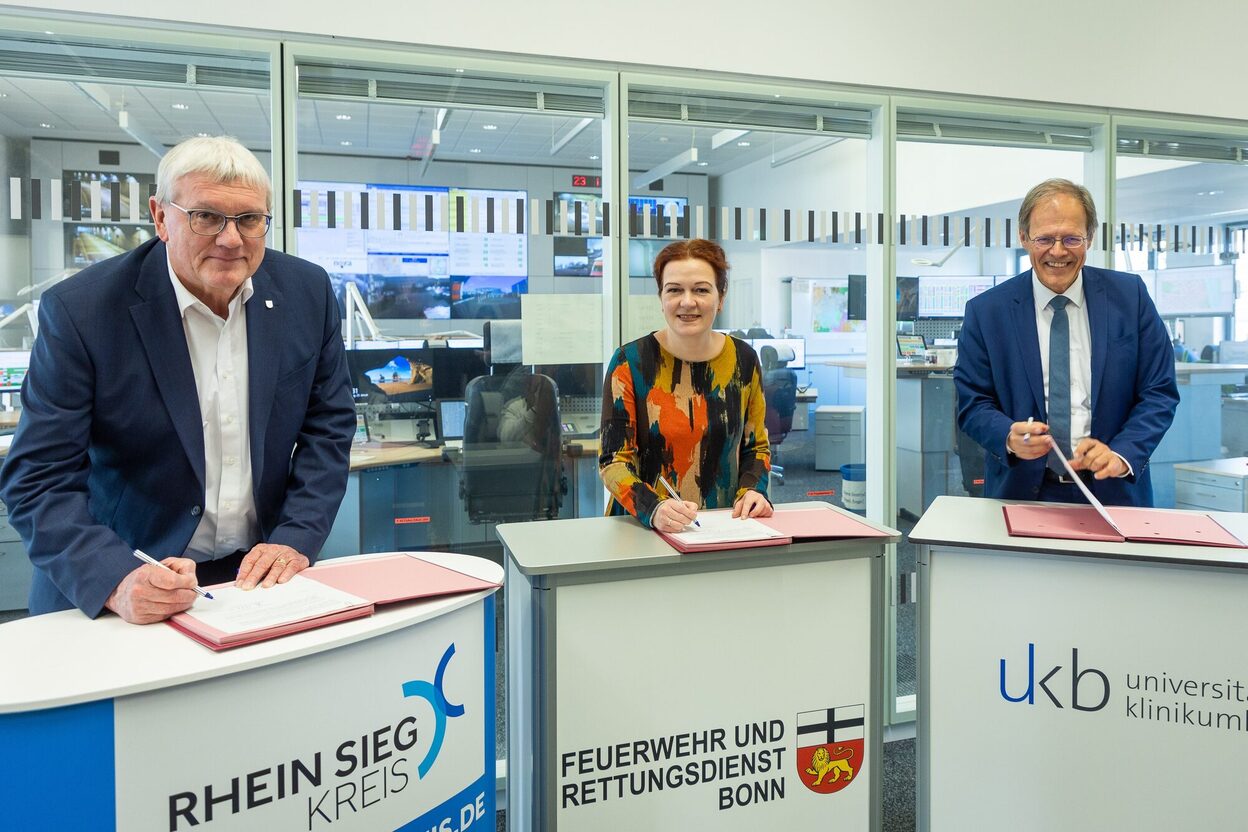 Das Bild zeigt (von links) Sebastian Schuster, Landrat des Rhein-Sieg-Kreises, Bonns Oberbürgermeisterin Katja Dörner und Prof. Wolfgang Holzgreve, Ärztlicher Direktor des Universitätsklinikums Bonn (UKB) bei der Unterzeichnung der öffentlich-rechtlichen Vereinbarung für die Trägergemeinschaft für das gemeinsame Telenotarztsystem.