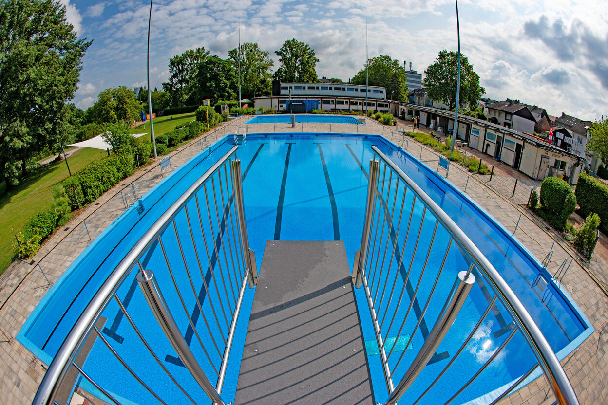 Blick vom Sprungturm auf das Schwimmerbecken mit neuer, strahlendblauer Folie.