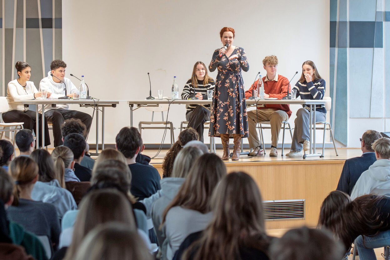 Oberbürgermeisterin Dörner steht auf einem Podium und spricht zu Schülerinnen und Schülern.