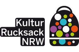 Das Logo zeigt einen gezeichneten schwarzen Rucksack mit bunten Punkten und den Schriftzug Kulturrucksack NRW