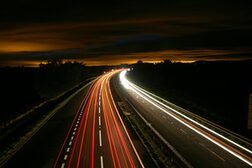 Die Nachtaufnahme einer Autobahn zeigt rote und weiße Lichtstreifen