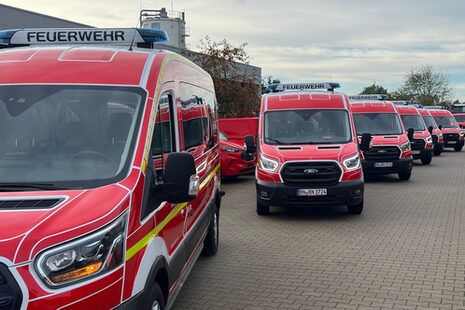 Mehrere Mannschaftswagen der Feuerwehr Bonn, die in einer Reihe stehen.