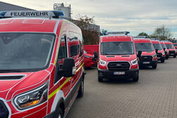 Mehrere Mannschaftswagen der Feuerwehr Bonn, die in einer Reihe stehen.