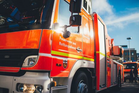 Feuerwehrauto im Einsatz mit Aufschrift "Feuerwehr und Rettungsdienst"