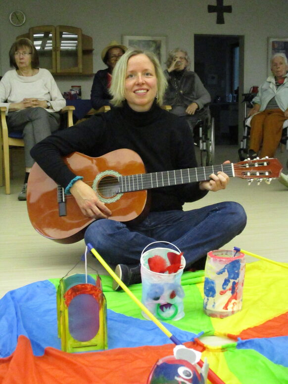 Eine Frau sitzt auf dem Boden mit einer Gitarre