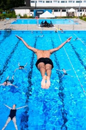 Drei Schwimmer rückwärts liegend im Wasser, wobei die Ohren unter Wasser sind, sodass die Klänge unter Wasser gehört werden können.