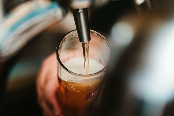 Unter einem Zapfhahn wird ein Bierglas gefüllt