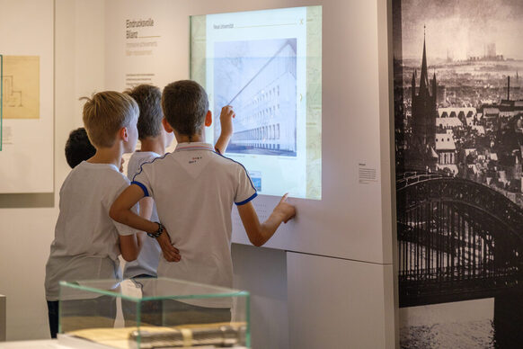Kinder vor einem Bildschirm in einer Ausstellung