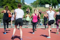 Menschen von hinten, wie sie draußen Sport machen