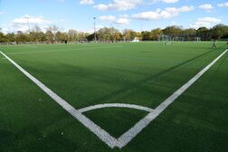 Mit weißen Linien markierter Eckballbereich auf einem Kunstrasenfußballplatz