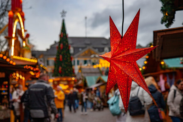 Ein beleuchteter Weihnachtsstern aus Papier an einem Verkaufsstand